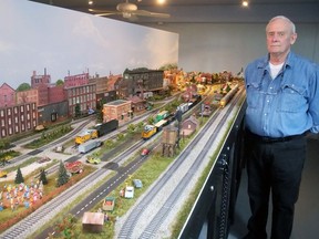 Randall Dravis stands next to a portion of the model railroad layout he designed with his wife Patty in their Delhi home. CHRIS ABBOTT