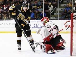 Owen Sound Attack goalie Corbin Votary makes a save against Sarnia Sting's Tyson Doucette (25) in the first period at Progressive Auto Sales Arena in Sarnia, Ont., on Friday, March 24, 2023. Mark Malone/Chatham Daily News/Postmedia Network