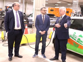 Rob Brewer, president and chief executive officer of PUC Services, Transport Minister Omar Alghabra and MP Terry Sheehan speak near an electric vehicle at PUC Services on Wednesday, April 5, 2023 in Sault Ste. Marie, Ont. (BRIAN KELLY/THE SAULT STAR/POSTMEDIA NETWORK)