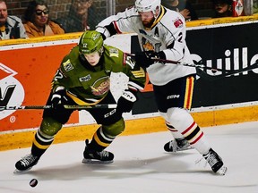 Connor Punnett of the visiting Barrie Colts crosschecks Nikita Tarasevich of the North Bay Battalion in the first period of their Ontario Hockey League second-round playoff opener Friday night.