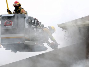 Kingston Fire and Rescue crews use a chainsaw to access the attic of 495 Davis Dr. in Kingston on Wednesday.
