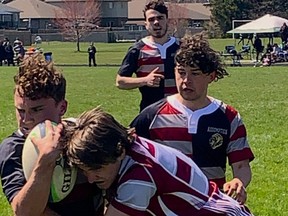 An Assumption College ball carrier is tackled by a Holy Trinity player on Thursday during AABHN senior boys rugby action. Staff