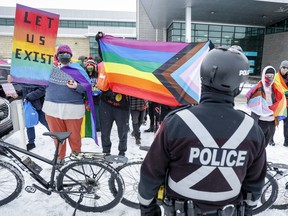 Ontario's NDP is urging the government to create community safety zones that would protect drag performers and LGBTQ communities.&ampnbsp;Supporters gather for a "Reading with Royalty" event as police look on at a library branch in Calgary, Alta., Monday, March 27, 2023.THE CANADIAN PRESS/Jeff McIntosh