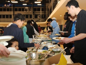 People grab food at an iftar, a meal that breaks a days' fasting period during Ramadan, at the Fort McMurray Islamic Centre on March 31, 2023. Vincent McDermott/Fort McMurray Today/Postmedia Network