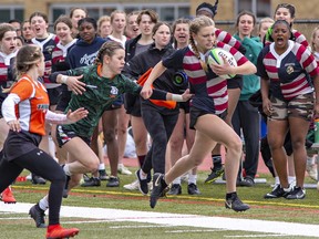 Assumption Lions ball carrier Charlotte Haggerty sprints past North Park Trojans defenders during an AABHN high school senior girls rugby match on Wednesday April 26, 2023 in Brantford, Ontario. Brian Thompson/Brantford Expositor/Postmedia Network