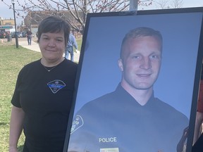 Leanne McPherson of the Queen's Park OPP detachment stands beside a portrait of slain OPP Const.  Greg Pierzchala at the “Getting After It” memorial bike ride held in Dunnville on Saturday, April 15. McPherson worked with Pierzchala at Queen's Park and was one many people to participate in the ride.  VINCENT BALL/BRANTFORD EXPOSITOR