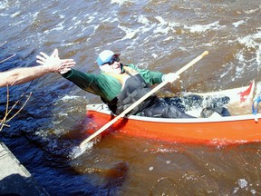 A paddler reaches for a high five as his canoe takes water during the 50th Raisin River Canoe Race on Saturday April 15, 2023 in Martintown, Ont. His craft would later capsize. Greg Peerenboom/Special to the Cornwall Standard-Freeholder/Postmedia Network