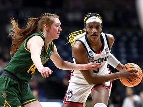 Aaliyah Edwards of the UConn Huskies drives past University of Vermont's Catherine Gilwee during a 95-52 win for the Huskies in Storrs, Conn., on March 18, 2023.
