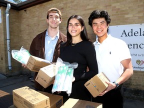 Members of the Queen's Dental Aid Network, from left, Connor Hamlyn, Kianna Niaki and Peter Hwang, outside Adelaide House on Cowdy Street on Thursday, April 21, 2023, with donated dental supplies to be used for vulnerable citizens.