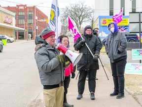 HEALTH COALITION RALLY Al Dupuis of the Algoma Health Coalition rallies a group of demonstrators outside of the constituency office of MPP Ross Romano last week.  The protest was in response to the province considering expanding private for-profit healthcare services. BOB DAVIES