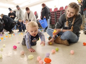 Julianne O'Neill, of Alvinston, watches her eight-month-old son, Grayson, take part Friday in the Petrolia Lions club Easter egg hunt.