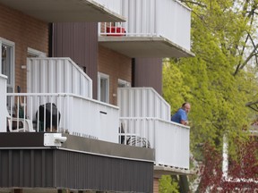 A man stands on the balcony of an apartment building at 125 Euphemia St., in Sarnia Tuesday morning.  Sarnia police issued a statement asking the public to avoid the area because of an ongoing incident.