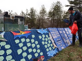 Teacher Matthew Coqu sets up a display about Salmon Squad, a program that saw young salmon raised at Plympton-Wyoming's Errol Village elementary for release into an area creek feeding Lake Huron.  (Paul Morden/The Observer)