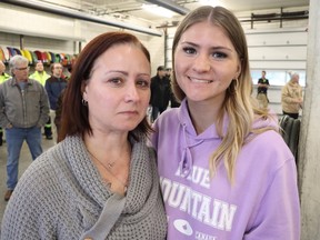 Melissa Boucher, left, and her daughter Triniti Boucher are shown at Friday evening's National Day of Mourning ceremony held at Sarnia's Clifford Hansen Fire Station.  They laid flowers during the ceremony in honor of Dan Boucher, Melissa's husband and Triniti's father, who died last summer following a workplace incident in Sarnia.  Paul Morden/The Observer