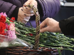 Flowers in memory of those killed or injured in the workplace are placed in a basket during Friday evening's National Day of Mourning ceremony held at Sarnia's Clifford Hansen Fire Station.  Paul Morden/The Observer