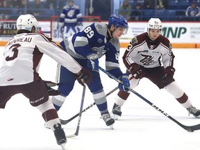 Nathan Villeneuve, middle, of the Sudbury Wolves, breaks between Cam Gauvreau, left, and Jonathan Melee, of the Peterborough Petes, during OHL action at the Sudbury Community Arena in Sudbury, Ont. on Friday March 17, 2023.
