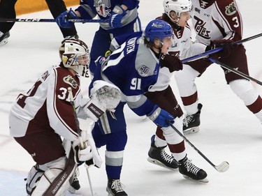 Evan Konyen, middle, of the Sudbury Wolves, and Brian Zanetti, of the Peterborough Petes, jostle for position in front of goalie Michael Simpson, of the Petes, during OHL playoff action at the Sudbury Community Arena in Sudbury, Ont. on Wednesday April 5, 2023. John Lappa/Sudbury Star/Postmedia Network