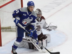 Ethan Larmand, left, of the Sudbury Wolves, and Michael Simpson, of the Peterborough Petes, keep an eye on the play during OHL playoff action at the Sudbury Community Arena in Sudbury, Ont. on Wednesday April 5, 2023.