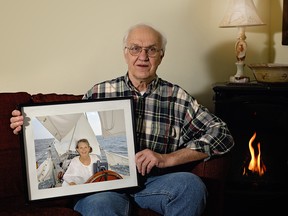 Henry Pietkiewicz holds up a portrait of His wife Karen, on board their sailboat following their retirement. TAMMY FEIGEHEN