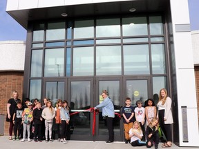 Assistant Principal Mila Flynn, far left, Principal Sarah Whelen, centre, teacher Chandi Govereau, far right, and Grade 3 students cut the ribbon on the recently completed École St. Mary School entrance Wednesday. The exterior was refreshed with a blue cross on the entrance, with further improvements inside, including in the learning commons and makerspace.