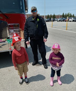 Hunter Wilson, 5, of Port Elgin and Mary Gault, 3, of Durham received firefighter’s helmets and fire safety information from Saugeen Shores Fire Department Captain Rob Blue at the Rotary Club of Port Elgin’s Hello Summer Expo May 20-21 at The Plex.