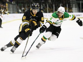 Sarnia Sting's Christian Kyrou (61) tries to get past London Knights' Isaiah George (4) during Game 3 in the OHL's Western Conference final at Progressive Auto Sales Arena in Sarnia, Ont., on Tuesday, May 2, 2023. (Mark Malone/Postmedia Network)
