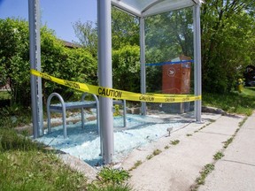 Broken glass litters a bus shelter at the corner of Manitoulin Drive and Tweedsmuir Avenue in London on Wednesday, May 24, 2023. Residents in the Fairmont area say a truck and homes also have been hit by stray pellets, possibly fired by people in cars. (Derek Ruttan/The London Free Press)