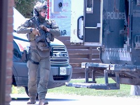 A police officer with weapon near the scene of a stabbing the night before stands on 6th Avenue East, just south of 19th streets east, on Monday, May 15, 2023 in Owen Sound, Ont. (Scott Dunn/The Sun Times/Postmedia Network)