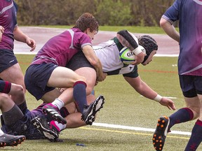 St. John's Eagles ball carrier Luca Casasanta manages to land across the try line despite a tackle attempt by an Assumption Lions player during an AABHN senior boys rugby match on Tuesday May 2, 2023 at Kiwanis Field in Brantford, Ontario. Brian Thompson/Brantford Expositor/Postmedia Network