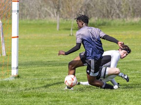 Forbes Nyakarombo of the Assumption Lions tries unsuccessfully to get control of a rebound off Pauline Johnson Thunderbirds goalkeeper Jacob Mardresano during an AABHN high school boys soccer match on Monday May 8, 2023 at John Wright Field in Brantford, Ontario. Brian Thompson/Brantford Expositor/Postmedia Network