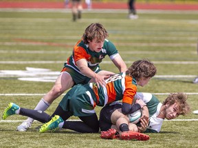 Micah DuChene (left) and Alex Stanley of the North Park Trojans bring down St. John's Eagles ball carrier Zack Ferriera during an AABHN high school senior boys rugby match on Tuesday May 9, 2023 at Kiwanis Field in Brantford, Ontario. Brian Thompson/Brantford Expositor/Postmedia Network