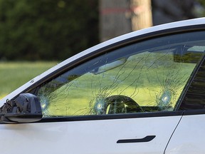 A white Tesla stopped on St, George Street near Tollgate Road appears to have three bullet holes in the driver's side window.