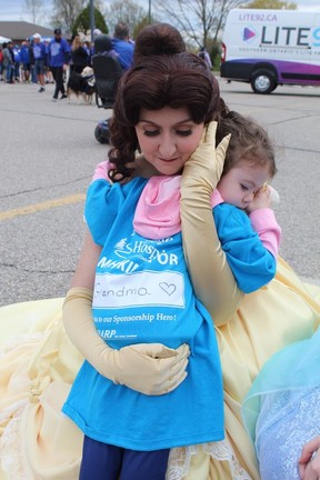 Three-year-old Olive Sousa gets a hug from the Rose Princess of the Glass Slipper Company at the Hike or Bike for Hospice in Brantford on Sunday, May 7. Olive participated in the fundraiser with her family in memory of her grandmother, Deborah Armstrong .  MICHAEL RUBY