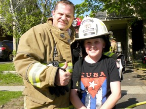 Brockville Interim Fire Chief Chris Paul poses with hero-of-the-day Rylan Hodge, 11, in front of Hodge's Dana Street home on Thursday afternoon. (THE RECORDER AND TIMES)