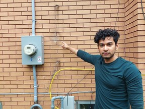 Shiv Gajiwala points to where the power line and meter used to be located on his Jasper Avenue home before it was ripped down by a falling tree branch during an ice storm in late February.  (Ellwood Shreve/Chatham Daily News)