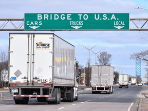 Transport trucks approach the Canada-U.S. border crossing in Windsor in March 2020. The skilled drivers at the wheel don't get to choose 'work from home.'
