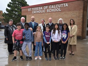 ALCDSB Trustees, school administrator and members of the Senior team stand with a group of Grade 3 students with the new school sign at St. Teresa of Calcutta School following an official renaming ceremony. Front Row (L-R): Group of Grade 3 students from the St. Teresa of Calcutta Catholic School Choir. Back Row (L-R): Kathy Turkington, School Board Trustee, Terry Shea, Chair of the Board of Trustees, David DeSantis, Director of Education, Stacey Porter, Principal, St. Teresa of Calcutta Catholic School, Shawn Murphy, School Board Trustee, Joanne Belanger, School Board Trustee, Carey Smith-Dewey, Superintendent of Education. Supplied photo