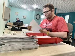 Yvon Wellsbury processes documents at the Yes We Can Kingston Co-operative on Monday.