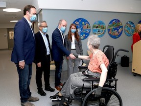 Kingston and the Islands MP Mark Gerretsen, from left, MPP Ted Hsu and Kingston Mayor Bryan Paterson greet a patient at Providence Care Transitional Centre