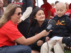 Eshe Lai speaks Friday at the start of a Vikes on Trikes fundraiser at Sarnia's Northern Collegiate. It raised more than $10,00O for the family of the 10-year-old girl who is battling leukemia. Principal Melissa Mallette holds the microphone. Paul Morden/The Observer