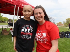 Eshe Lai, 10, and Kate Walls are at Northern Collegiate in Sarnia Friday before the start of the Vikes on Trikes fundraiser. Walls is a student in a leadership class that organized the event that raised more than $10,000 to help the family of the youngster who is battling leukemia. Paul Morden/The Observer