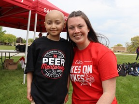 Eshe Lai, 10, and Kate Walls are at Northern Collegiate in Sarnia Friday before the start of the Vikes on Trikes fundraiser.  Walls is a student in a leadership class that organized the event that raised more than $10,000 to help the family of the youngster who is battling leukemia.  Paul Morden/The Observer