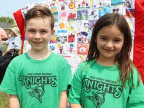 Jason Kennedy, 6, and Lennan Plain, 7, pupils at Sir John Moore elementary school, stand next to a quilt pupils at the school helped make. It was unveiled Tuesday during a ceremony marking the 200th anniversary of Corunna being selected as a potential site for the capital of Canada. (Paul Morden/The Observer)