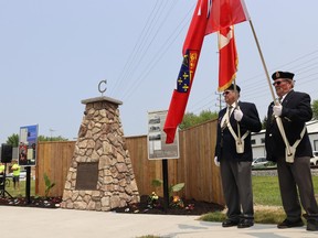 The color guard from Canadian Legion Branch 447 stands next to a memorial in Corunna marking the community's selection 200 years ago as a potential site for the capital of Canada. A ceremony re-dedicating the memorial was held Tuesday. (Paul Morden/The Observer)
