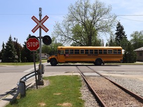A school bus crosses railroad tracks.