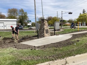 Workers make improvements to a site with a cairn marking what would have been St. George's Square in Corunna, if the town had been named the capital of Canada. (Supplied)