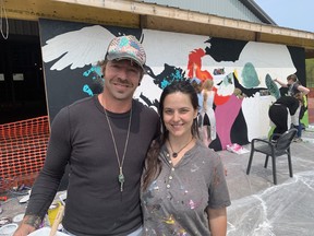 Benjamin Swatez and Azerine De Luca stand in front of a mural on May 10 that is being created through a project initiated by the Long Point Biosphere Region at Long Point Eco Adventures.  VINCENT BALL/BRANTFORD EXPOSITOR