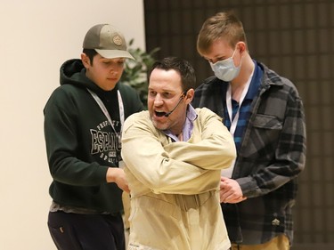 Keynote speaker Scott Hammell is fitted with a straitjacket during his address to students at the Rainbow District School Board Student SenateÕs Leadership Through Action Conference at Cambrian College in Sudbury, Ont. on Wednesday May 3, 2023. Hammell is a magician and ÒGuinness World Record holder.Ó A release issued by the Rainbow board said, ÒScott Hammell has been entertaining professionally since 1998, and has taken record-breaking stunts to new heights - by hanging upside down from a hot air balloon locked in a straitjacket, jumping from an airplane while blindfolded, juggling explosives, catching a bullet fired from a high-powered sniper rifle, and completing a card trick while skydiving.Ó John Lappa/Sudbury Star/Postmedia Network