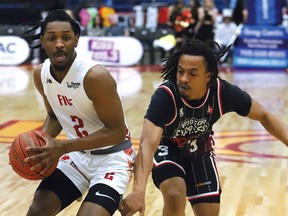 AJ Mosby Jr., of the Sudbury Five, drives to the basket against Nick Garth, of the Windsor Express, during playoff basketball action at the Sudbury Community Arena in Sudbury, Ont. on Friday May 5, 2023.