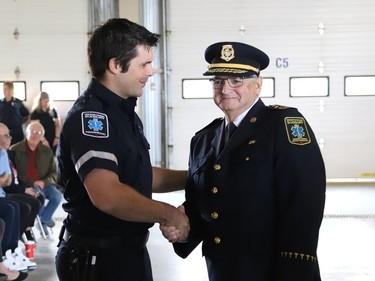 Adam Schjerning, left, is welcomed into the paramedic service by Joseph Nicholls, Chief of Fire and Paramedic Services, at the launch of Paramedic Week at the Lionel E. Lalonde Centre in Azilda, Ont. on Tuesday May 23, 2023. A total of 14 new paramedic recruits were recognized for completing their orientation. John Lappa/Sudbury Star/Postmedia Network